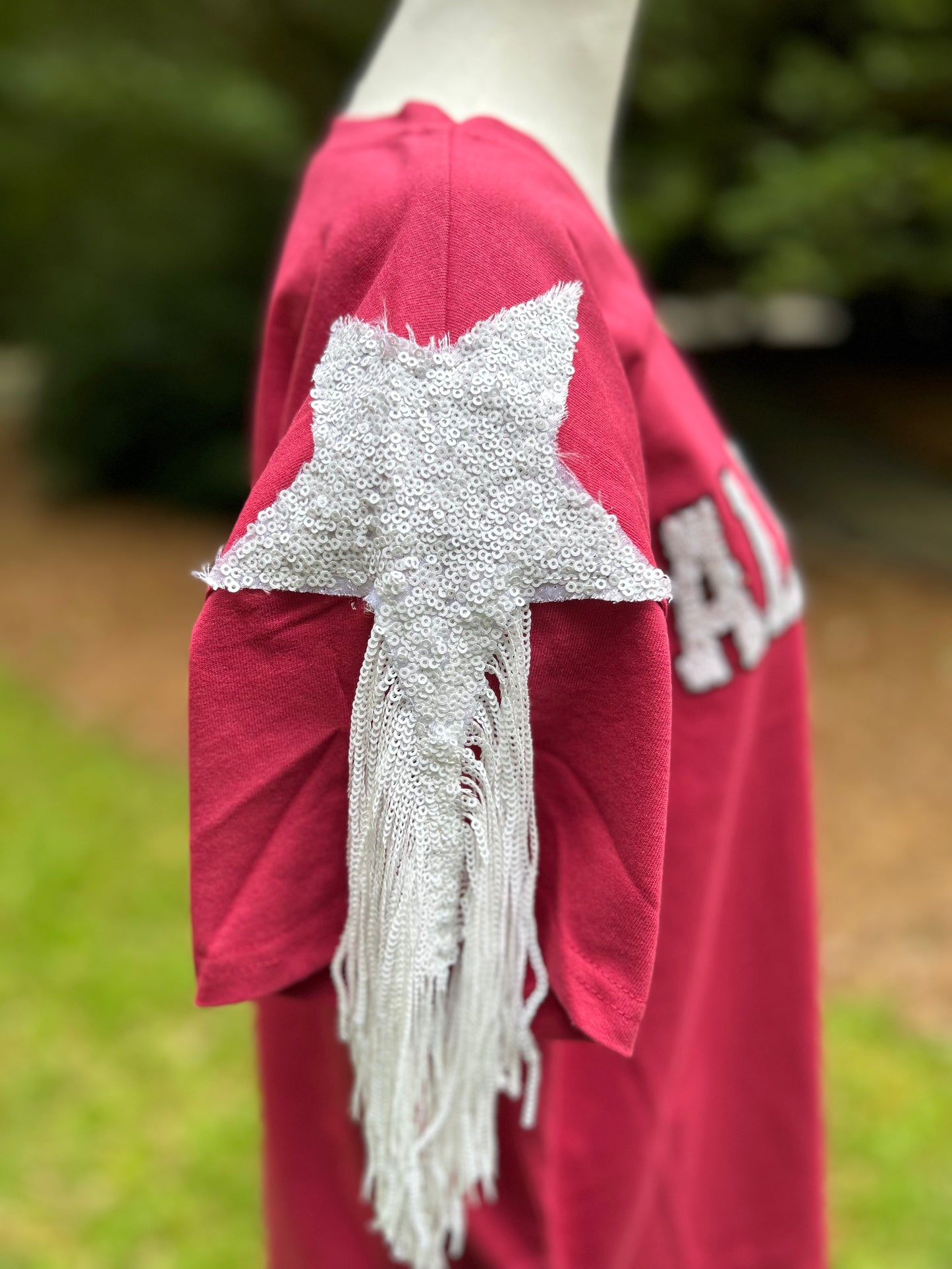 Alabama crimson gameday shirt with white sequins spelling out Alabama. Star sequin and fringe detail on the sleeves.