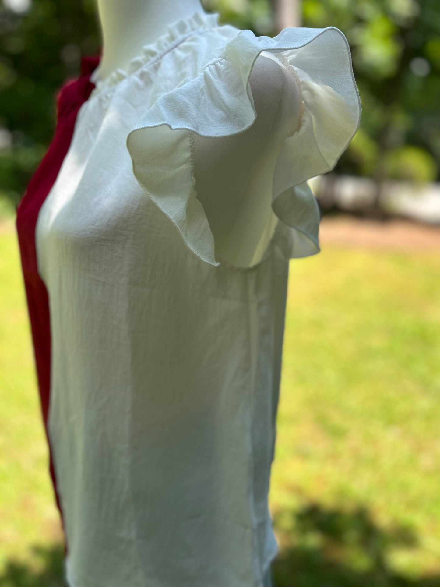 Crimson and white colorblock top with ruffle details on the sleeves and neckline.
