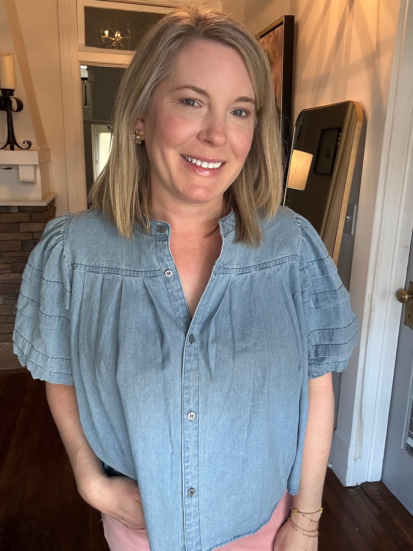 Denim button-up top with pleated details.