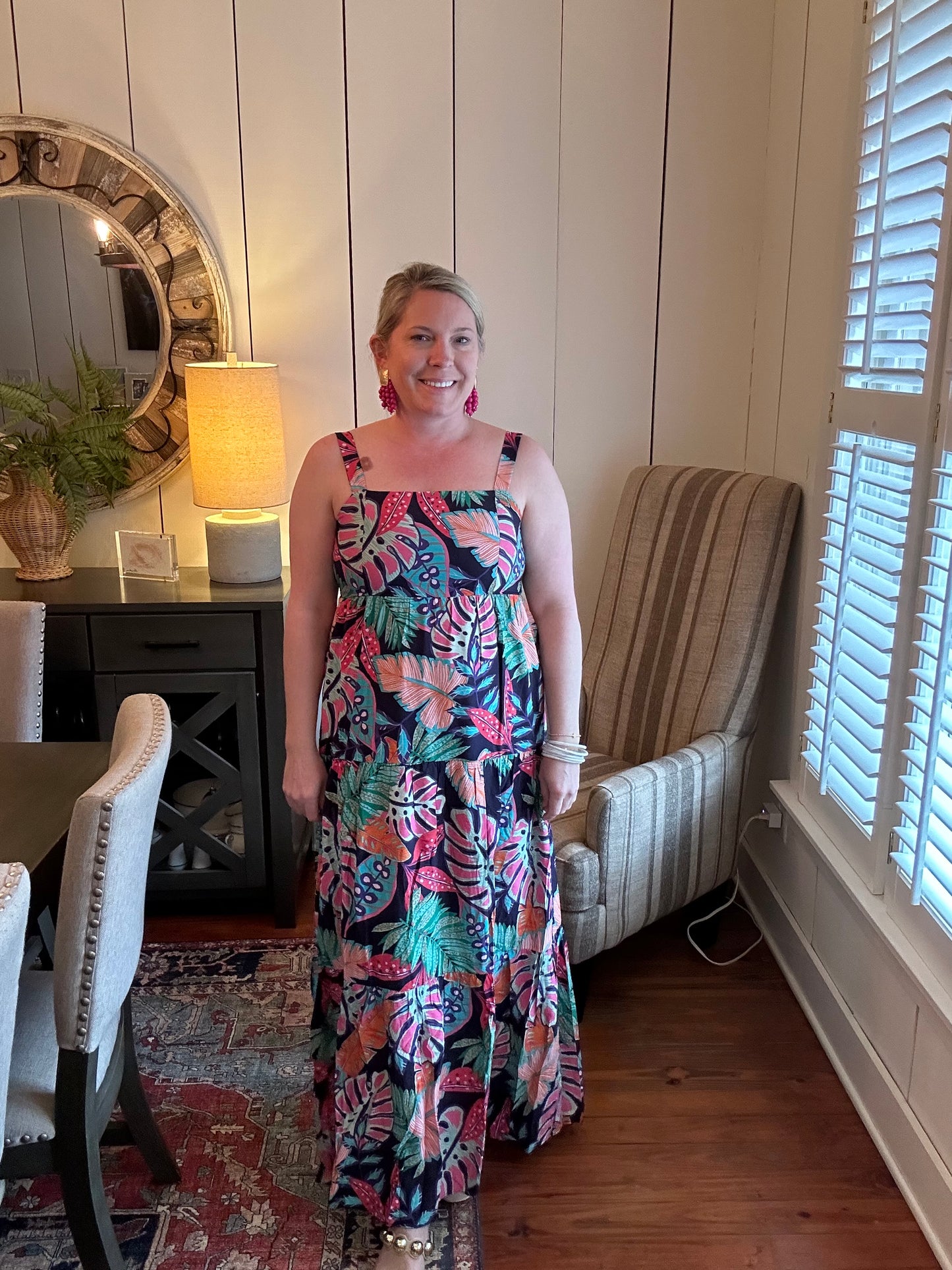 Long maxi dress with 2in straps over shoulders which are adjustable. Smocked back gives some stretch. Navy blue base color with tropical flowers and leaves all over dress in pinks, greens, whites, orange. Dress is lined and has pockets.