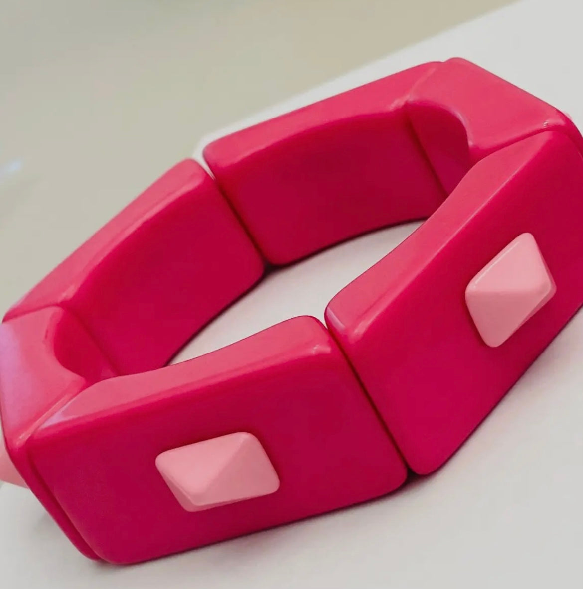 Pink plastic tool with geometric design on a white background