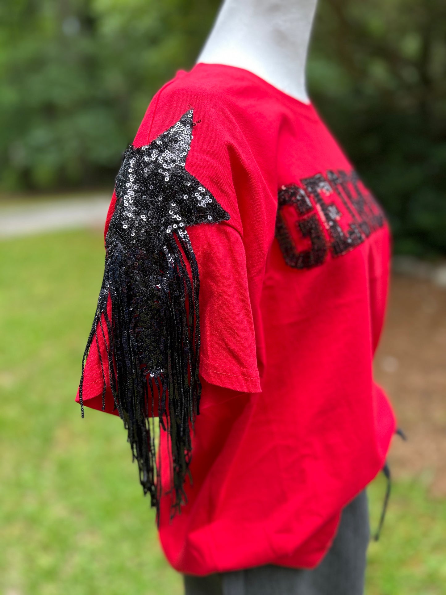 Black sequin star and fringe detail on sleeves with black sequins spelling out Georgia.