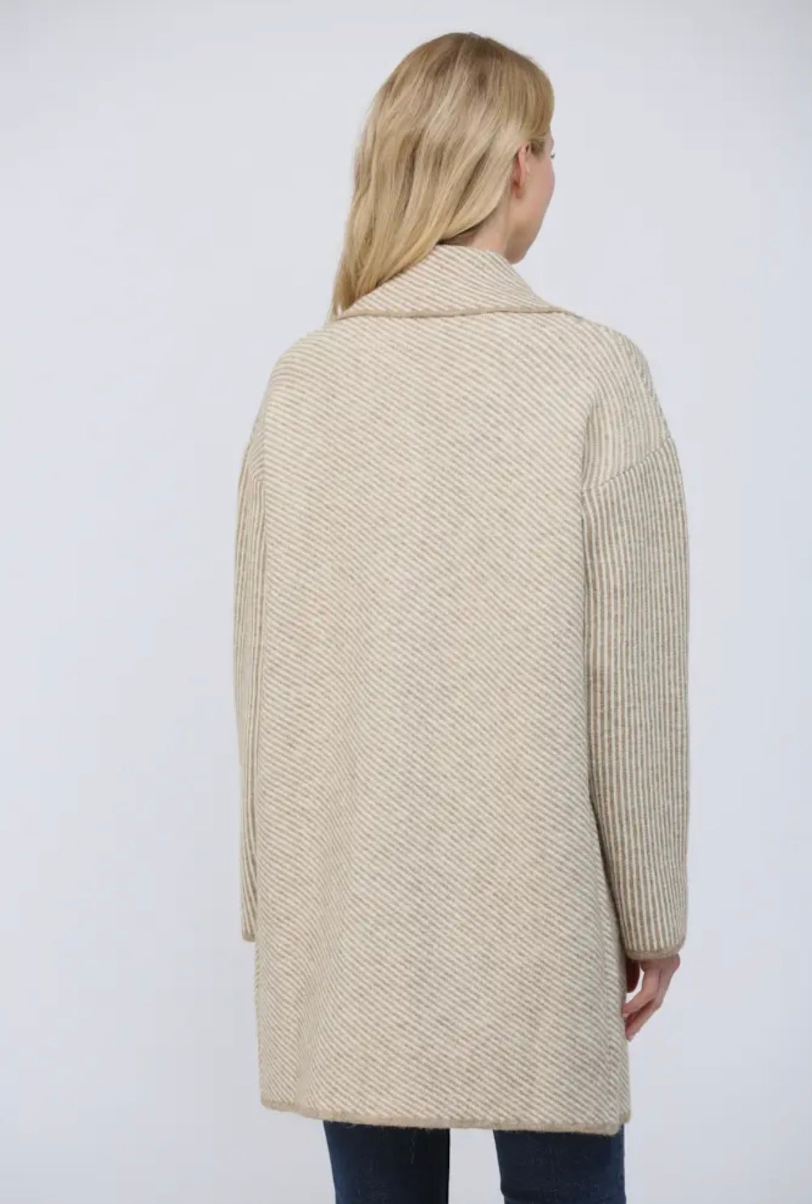 Woman wearing a beige coat against a white background