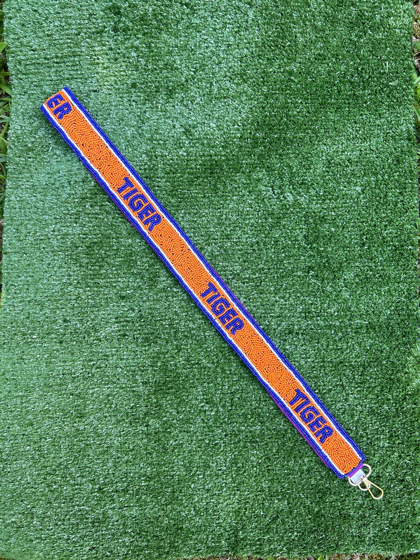 Beaded gameday strap for stadium bag. Orange and purple spelling out Tiger. 