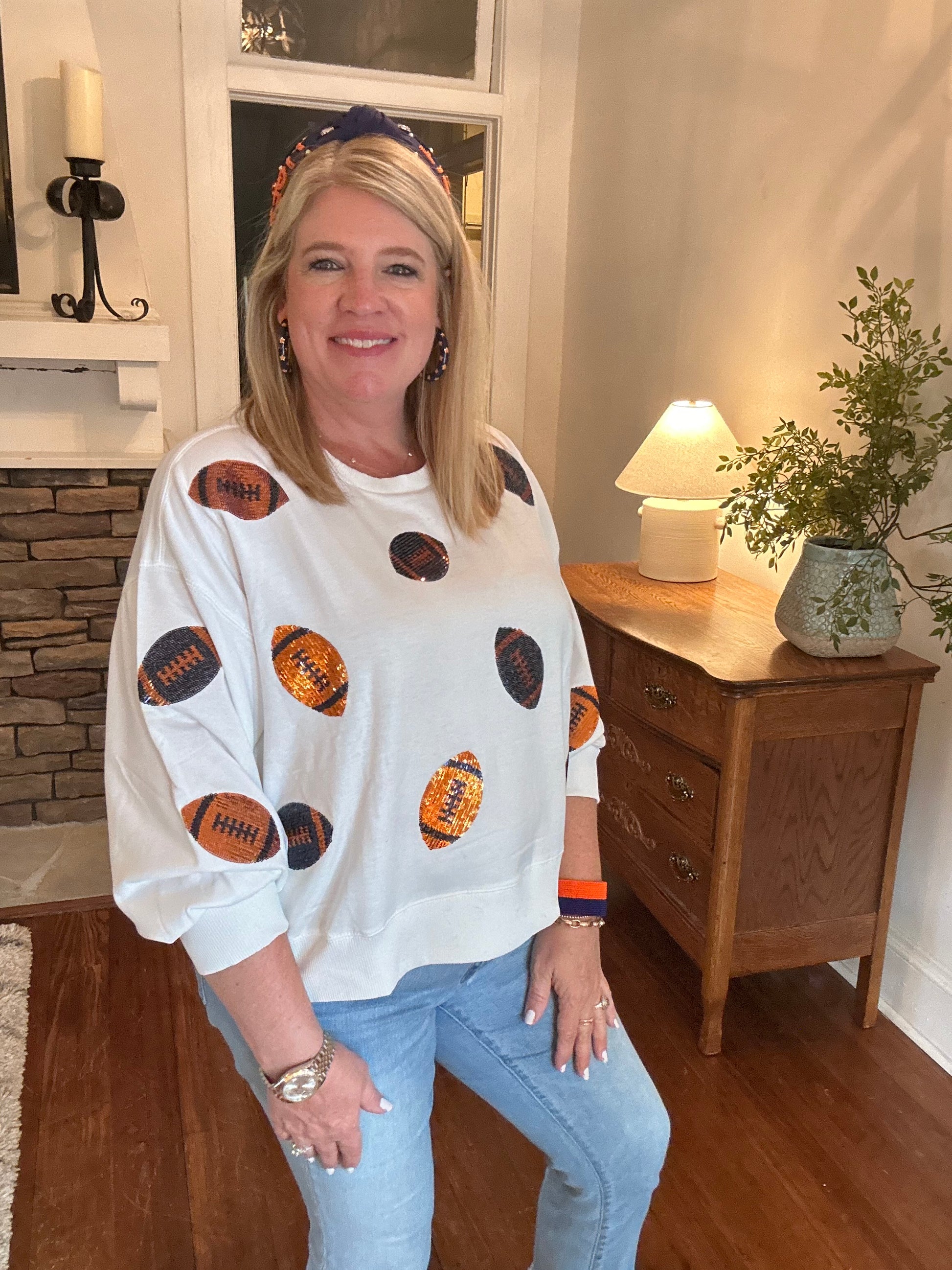 Navy and orange sequin footballs on a white sweatshirt 