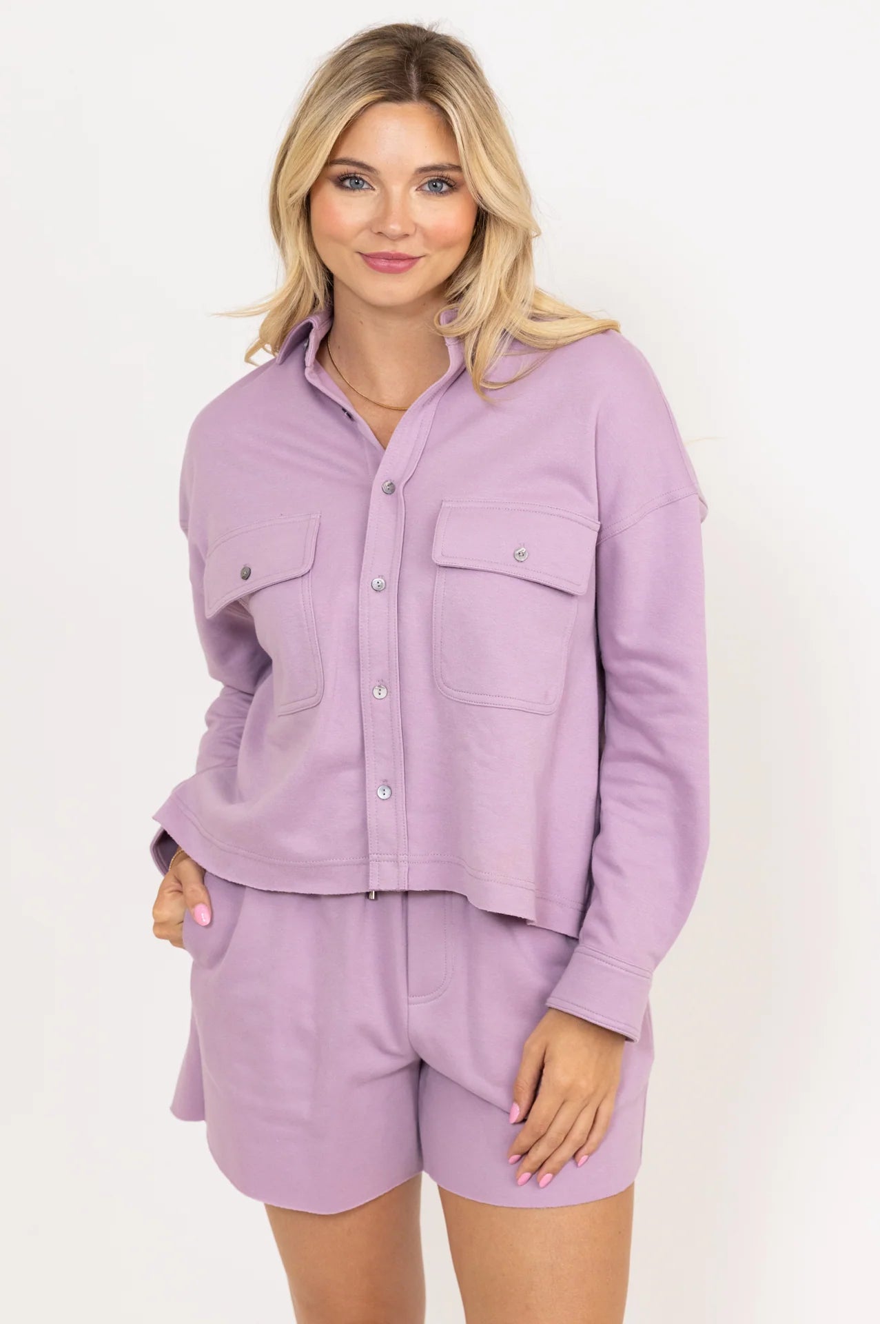Woman wearing a lavender shirt and shorts set on a white background