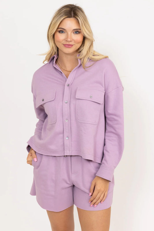 Woman wearing a lavender shirt and shorts set on a white background