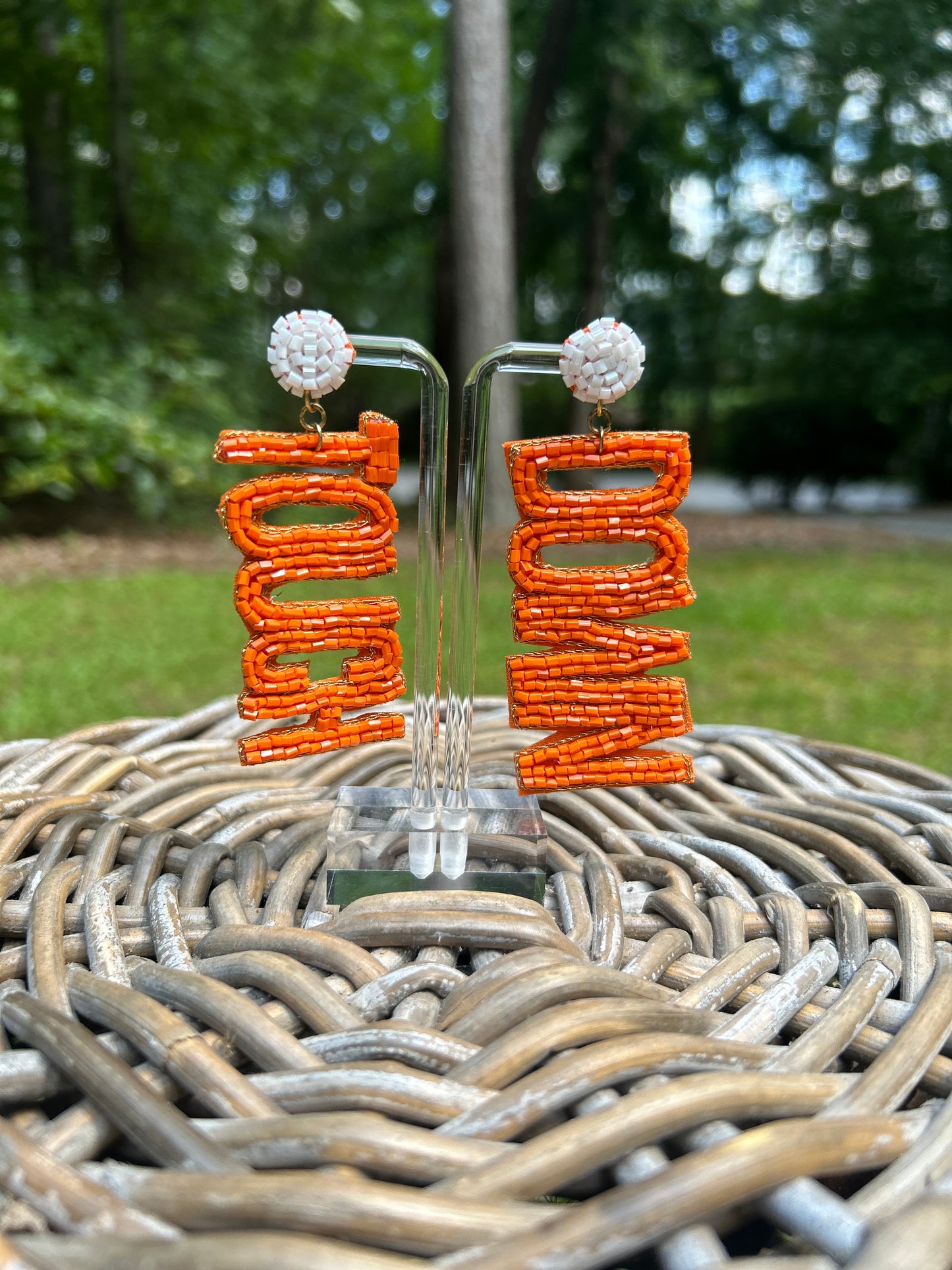 Lightweight, beaded earrings in orange and white. One earring says Touch and the other earring says Down. Beaded letters are in orange and the beaded stud part is white.  