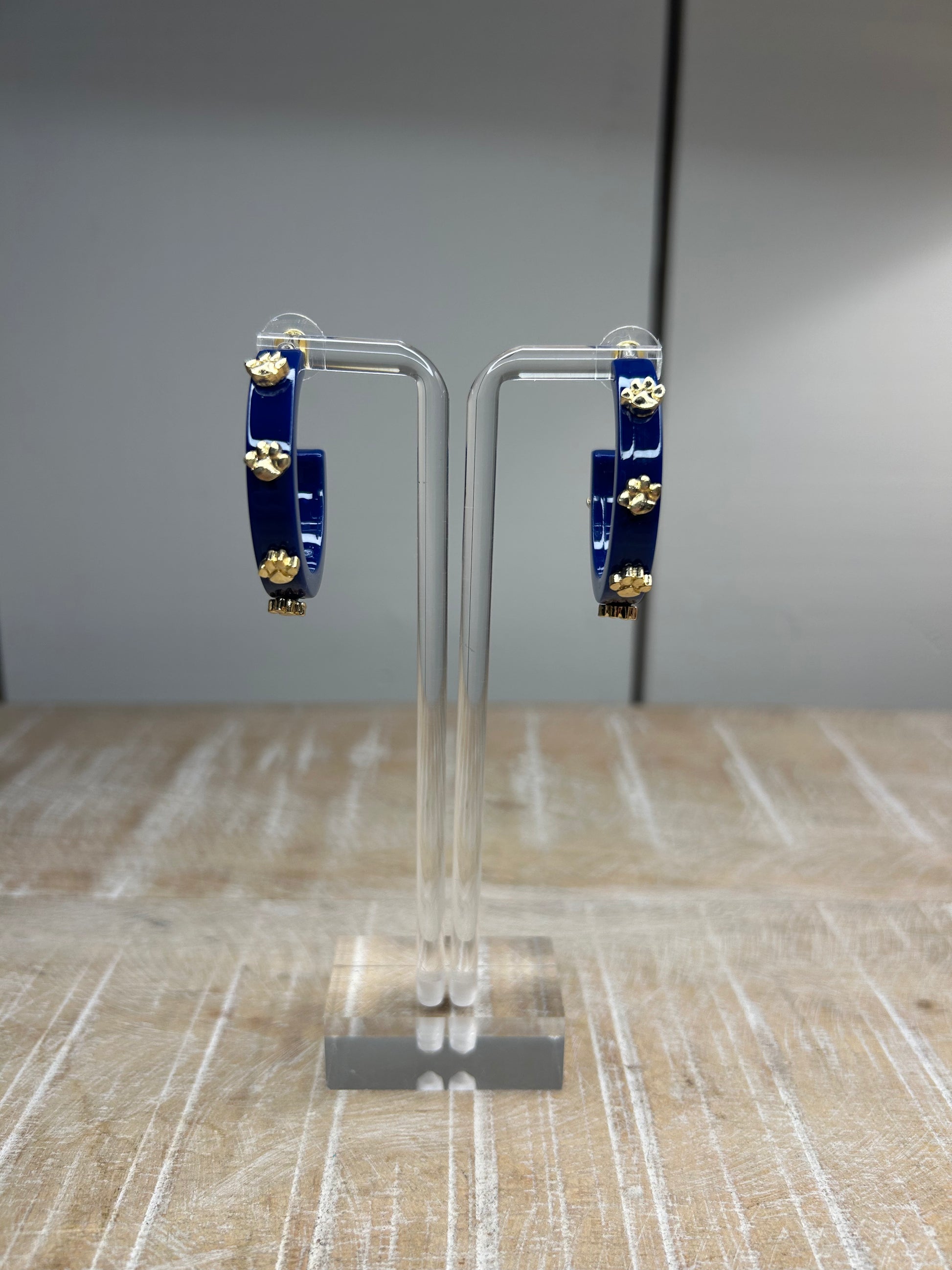 Navy hoops earrings with gold 3D tiger paws placed evenly on the hoops