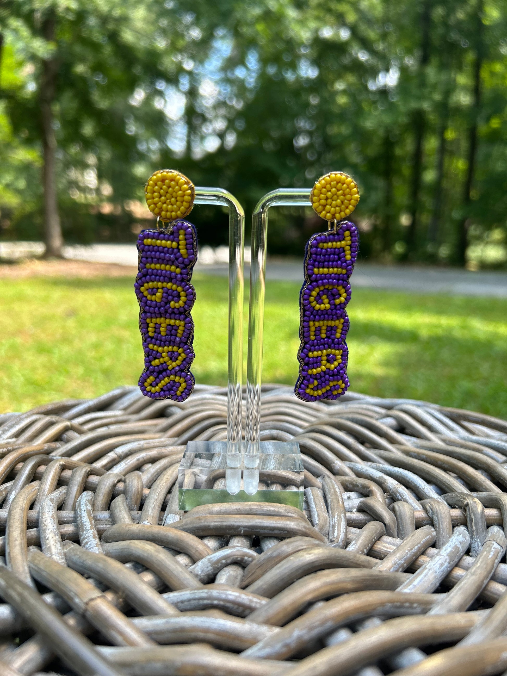 Lightweight, beaded earrings in purple and gold spelling out Tigers. 