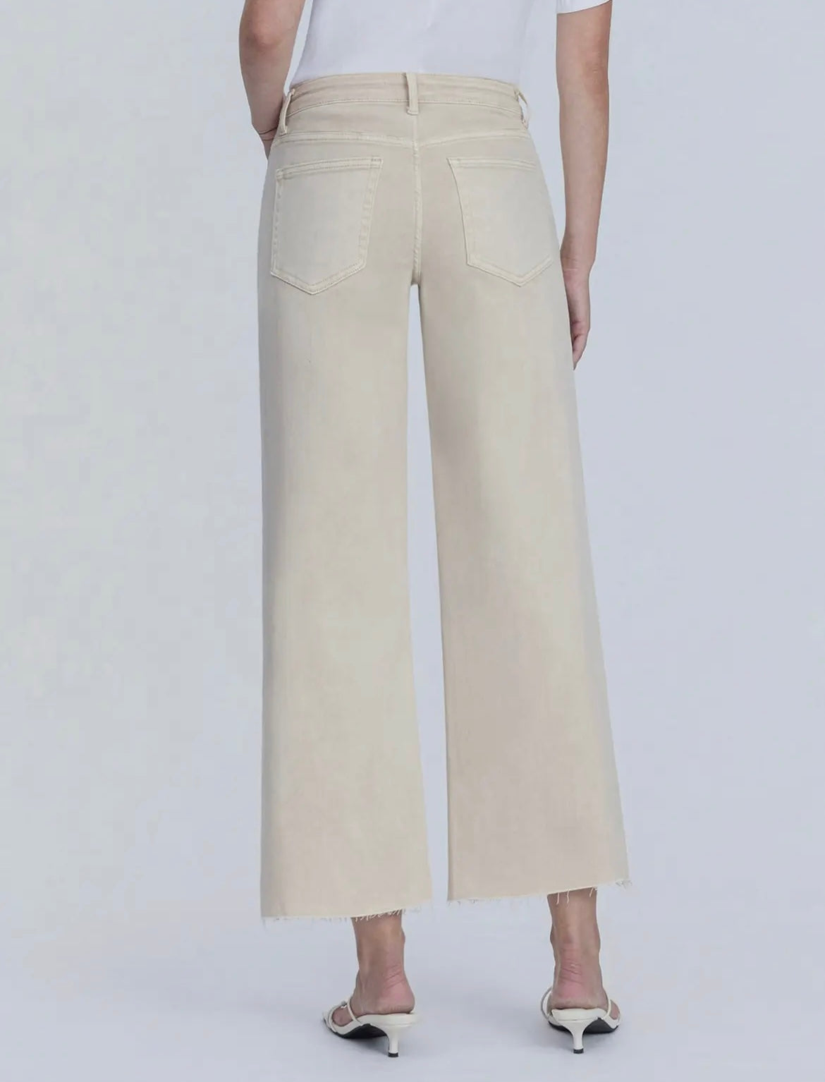 Person wearing beige wide-leg pants on a white background